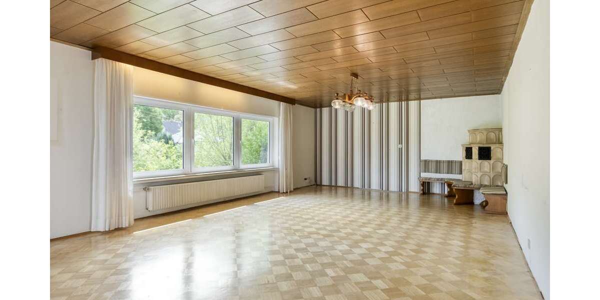 Wohnzimmer mit Panoramafenster und Balkonzugang